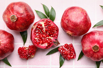 Delicious pomegranates on pink tile background