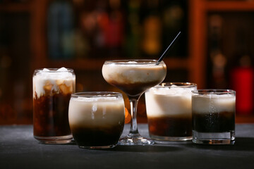 Glasses of tasty White Russian cocktail on table in bar
