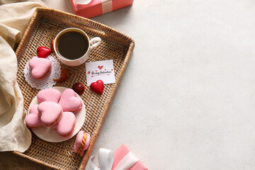 Tray with tasty heart-shaped macaroons and cup of coffee on white background