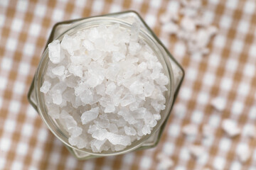 Jar of sea salt on table, closeup