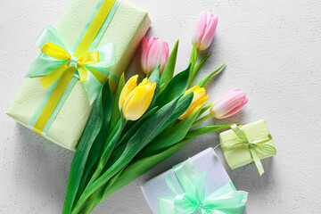 Beautiful tulip flowers and gift boxes for International Women's Day on light background