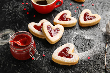 Tasty cookies and jam for Valentine's Day celebration on dark background, closeup