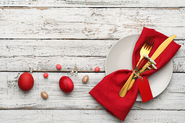 Stylish table setting for Easter celebration on light wooden background