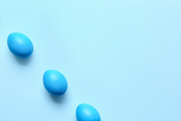 Blue painted Easter eggs on color background
