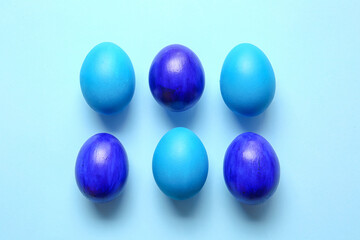 Blue painted Easter eggs on color background