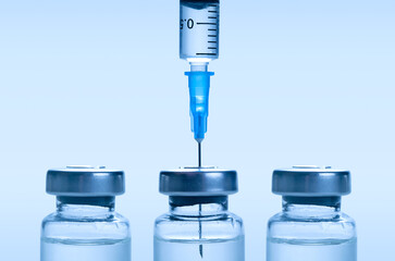 Medical syringe with a needle and a bollte with vaccine.