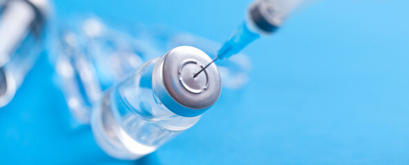 Medical syringe with a needle and a bollte with vaccine.
