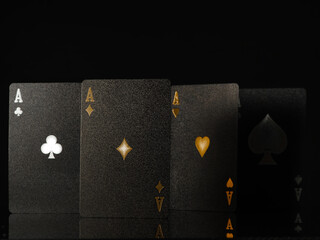 Playing black cards, four aces on a black background. Casino, online casino. gambling, poker, gambling business. Advertising, banner. There are no people in the photo. Minimalism.