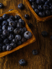 Close-up. Blueberries in bowls and on the table. Wooden texture. High angle view. Vitamins, antioxidants, healthy lifestyle, diet food, environmental protection. There are no people in the photo.