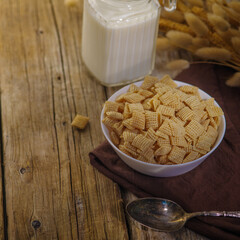 Whole grain cereal, snacks in a bowl, milk and a bunch of cereals. Wooden texture. Instant breakfasts, fast satisfaction of hunger, vitamins, minerals, fiber. Menu design, food blog.