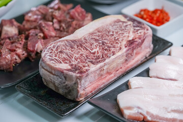 Korean beef barbecue a popular Korean dish with small side dishes set, Beef, pork, garlic, minced peppers, fresh vegetables and fresh vegetable salad for korean barbecue