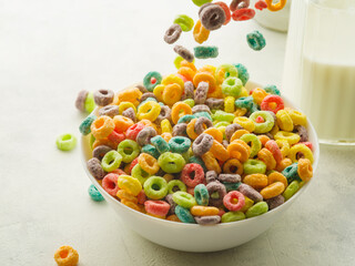 Crispy cereal fruit snacks in a white bowl. Snacks in a state of frozen flight on a white background. Quick breakfasts, sweet food. Favorite baby food, vitamins, antioxidants.