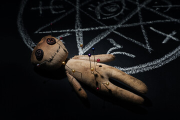 Voodoo doll near ritual circle drawn on black table