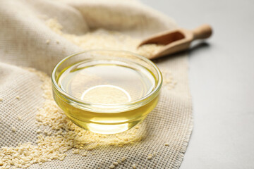 Fresh sesame oil and seeds on white table, closeup. Space for text