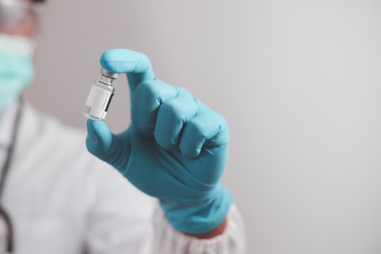doctor or scientist in the COVID-19 medical vaccine research and development laboratory holds a syringe with a liquid vaccine to study and analyze antibody samples for the patient.

