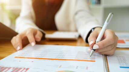 Financial analysts take notes on report papers.