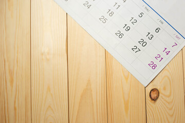 Calendar on wooden table with copy space, business meeting schedule, trip planning or project goals and reminder ideas.