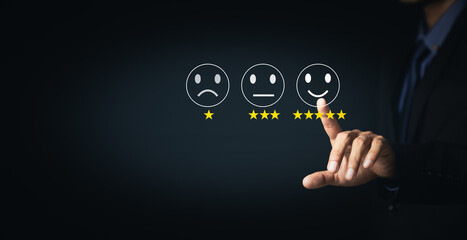 Fototapeta premium Customer Service and Satisfaction Concept Businessmen touch the virtual screen on happy smiley icons to achieve service satisfaction and feedback with excellent rated reviews.
