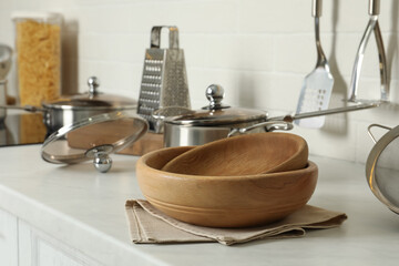 Wooden bowls and different cooking utensils on kitchen counter