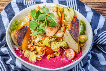 A serving of grilled chicken salad with vegetables in a round white bowl