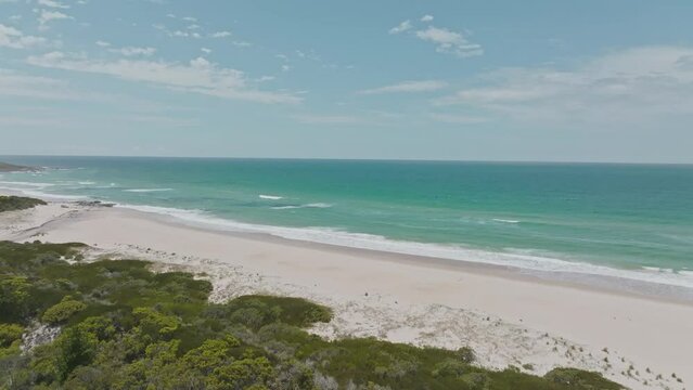 Stunning high angle aerial panoramic drone footage of Lagoons Beach Conservation Area  and Lower Marsh Creek near the village of Scamander on the east coast of Tasmania, Australia on a sunny day.