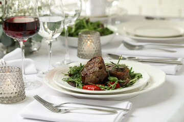 Delicious grilled meat with vegetables and wine served on table in restaurant