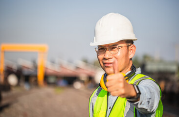 Selective focus of Engineer man showing thumb up, Factory worker smiling with giving thumbs up as sign of success