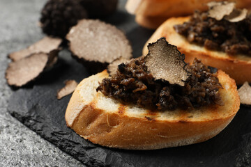 Delicious bruschettas with truffle sauce on grey table, closeup