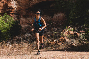woman ultra trail marathon runner running through the rock mountain