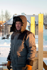 Portrait of a worker in protective workwear with a hood on his head