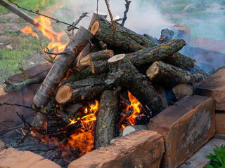 Roaring fire with blurred flames from wood logs in a stone firepit