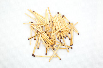 Wooden matches lie in a mountain, close-up. White background