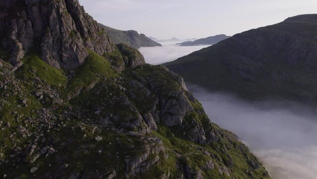 Aerial drone flying over ridgeline at sunrise with cloud inversions
