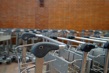 Rows of Airport luggage carts with brick wall