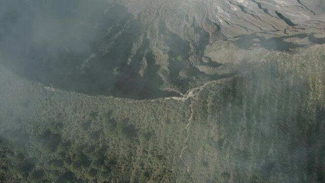 Aerial birds eye shot of spectacular Chichonal Volcano with crater lake in the valley during sunny day -