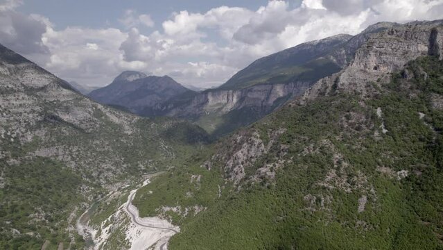 Drone video of frontal plane over the mountain pass on the Sh20 road in Grabom, Albania, Leqet and Hotit you can see houses of the village.