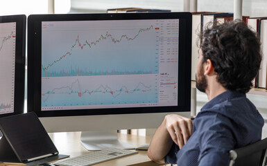 Caucasian happy male bearded trader investor freelancer smiling standing typing data information on computer working at home office selling trading buying stock exchange for client and customer.