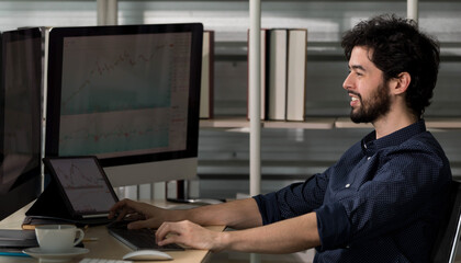 Caucasian happy male bearded trader investor freelancer smiling sitting typing data information on computer working at home office selling trading buying stock exchange for client and customer.