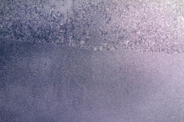 Full frame macro abstract texture background of a frosted glass window pane with natural ice crystals colorized in a lavender hue