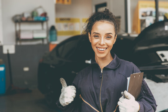 happy woman worker working for car auto service trumbs up smiling