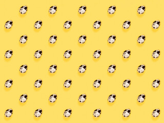The easter background with the quail brown eggs pattern on the trendy yellow background.