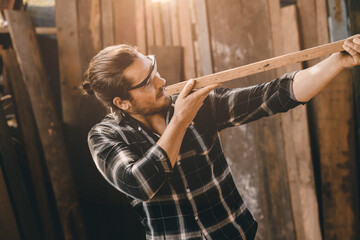 The carpenters man high experienced wood worker making furniture. Master of woodcraft male looking at wood panel.