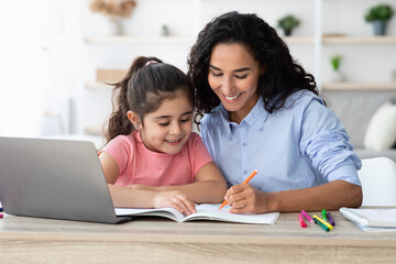Homeschooling Concept. Caring Young Mom Helping With Homework To Her Little Daughter