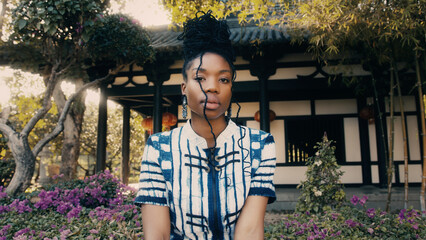 Fashion portrait of a beautiful African-American woman by a Chinese architecture in the background