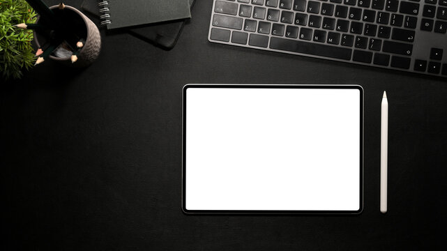 Tablet computer white screen mockup on modern black table background.
