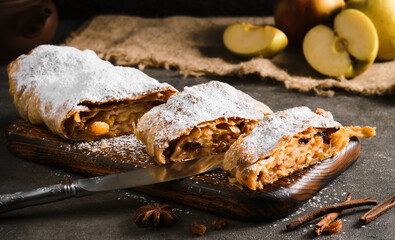 Apple pie - strudel or apfelstrudel, sliced ​​pie with apples and spices on a gray table,...