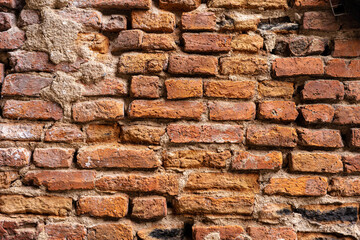 Brown aged brick wall with cracking parts.