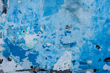 Old grunge wall painted by blue color.