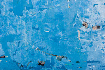 Old grunge wall painted by blue color.