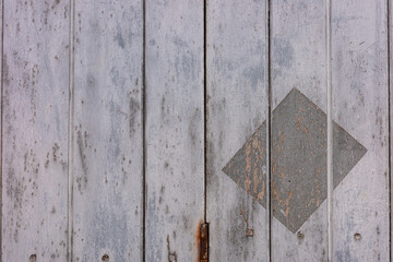 Close up on painted grey wooden wall with rectangle stamped.